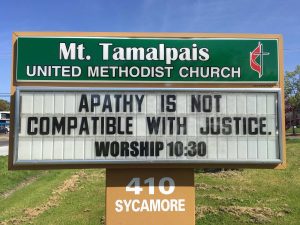 Sign Text: Apathy is not compatible with Justice. Worship 10:30am