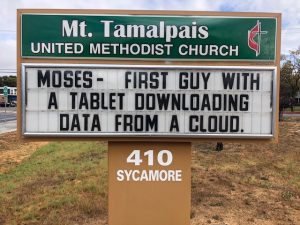 Sign Text: Moses - First guy with a tablet downloading data from a cloud.